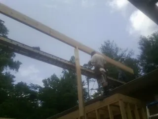 Carpenter setting a ridge beam over a new addition frame — Ice Dam Removal by Roofing Brothers in Tabor