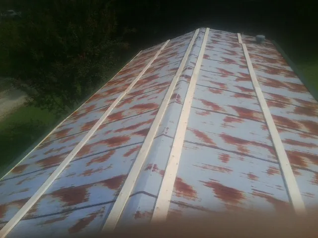 Rusted metal roof panels with new wood purlins before replacement — Storm Damage Roof Repair in Tabor by Roofing Brothers